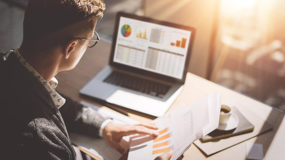 man at laptop with data on screen